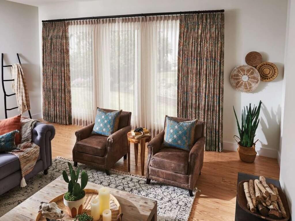 Graber custom drapery panels with flowing fabric adding elegance and light control to spacious living room windows